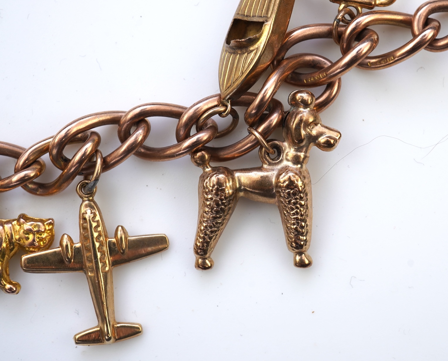 A gold charm bracelet, mid 20th century